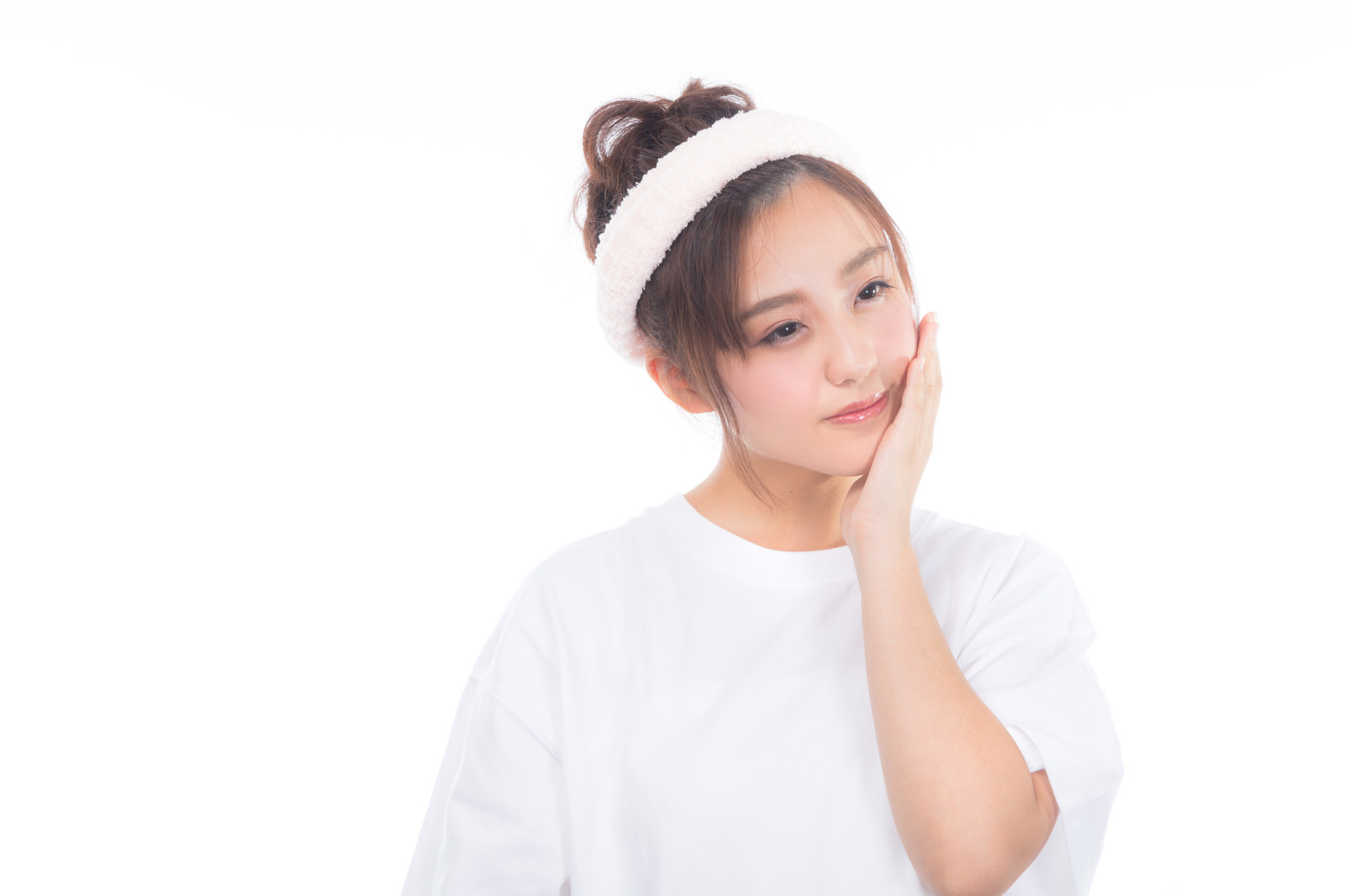 スキンケアを終えて頬に手を当てる女性