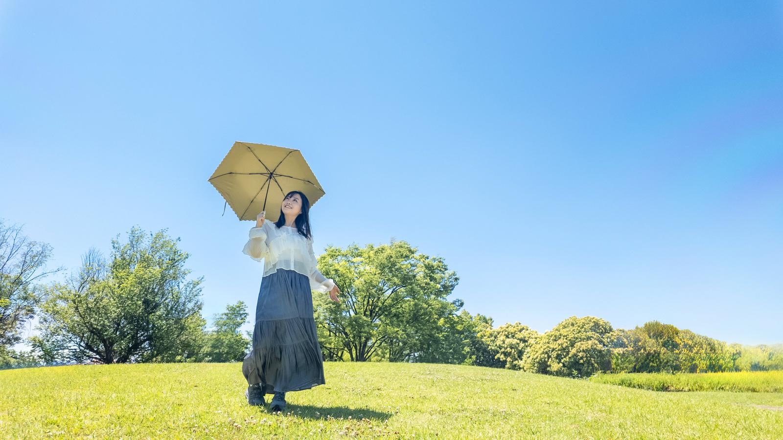 日傘で日差しを避けながら外を歩く様子